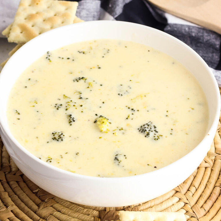 Creamy Broccoli Cheese Soup in white bowl on round placemat