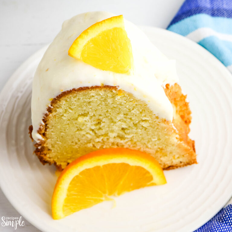 Slice of frosted orange pound cake on white plate