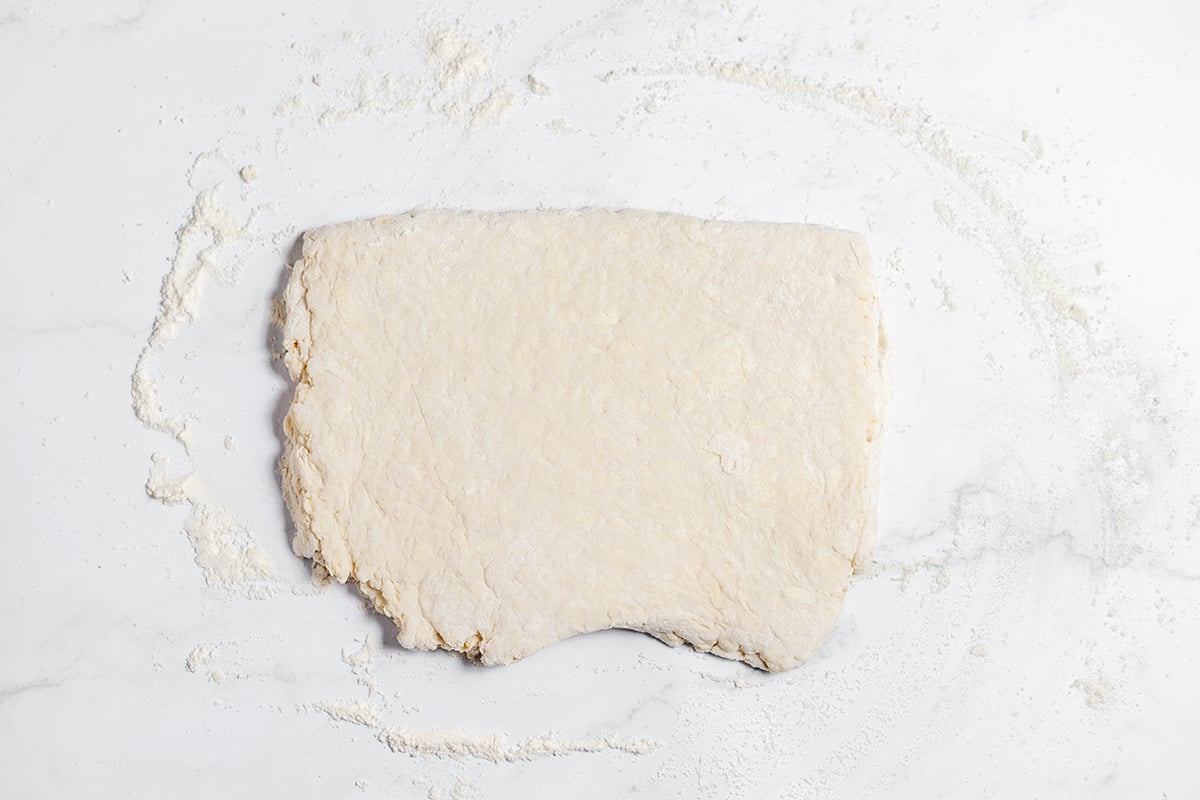 Biscuit dough rolled out on counter.