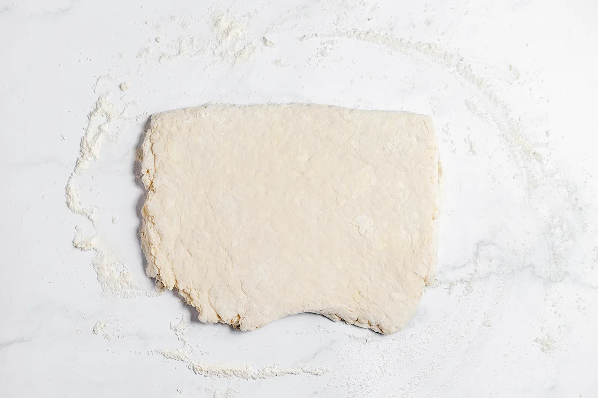 Biscuit dough rolled out on counter.