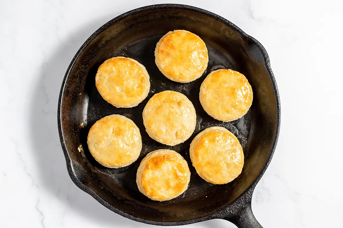 Biscuits in cast iron skillet with brushed with butter.