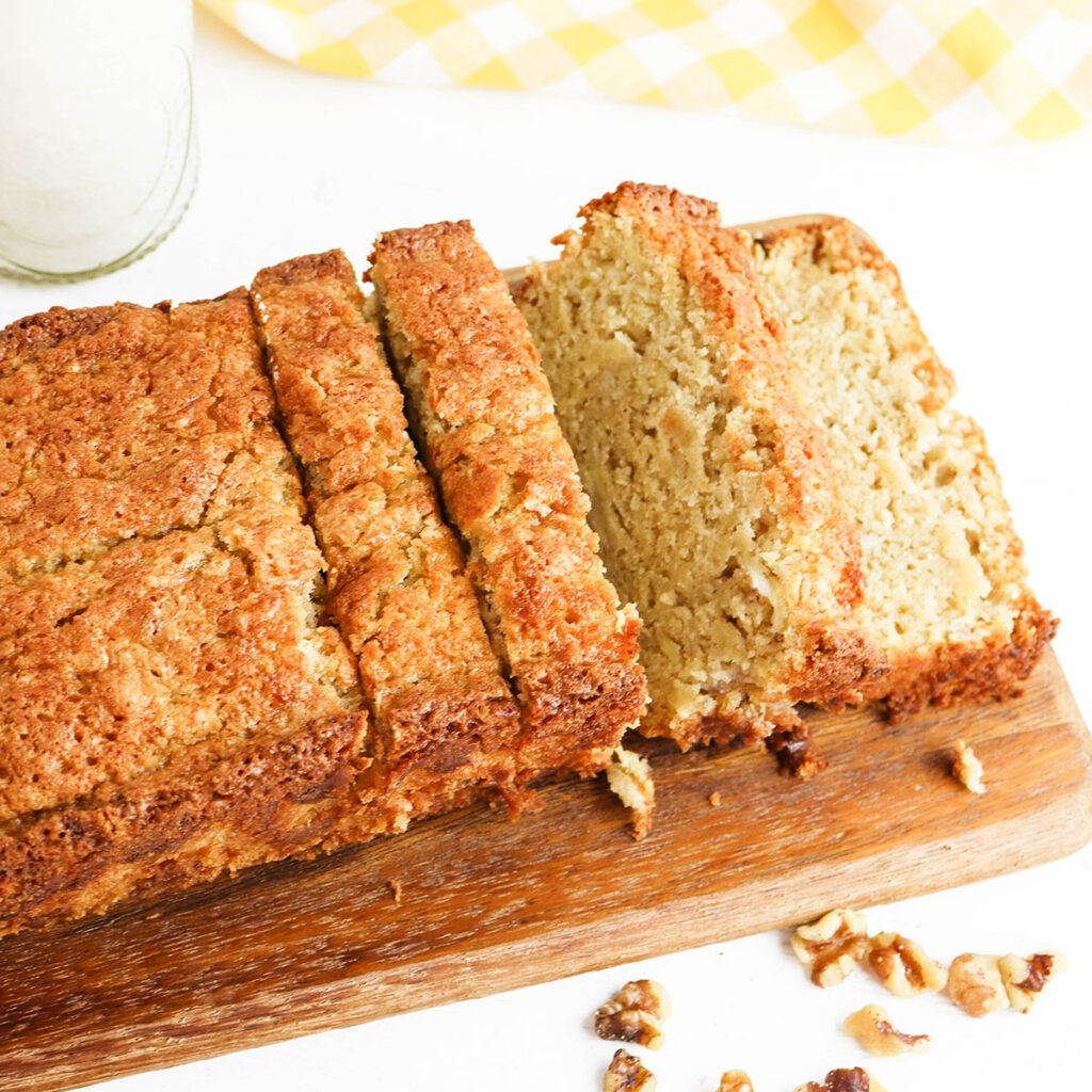 Sliced Banana Nut Bread on wooden serving board.
