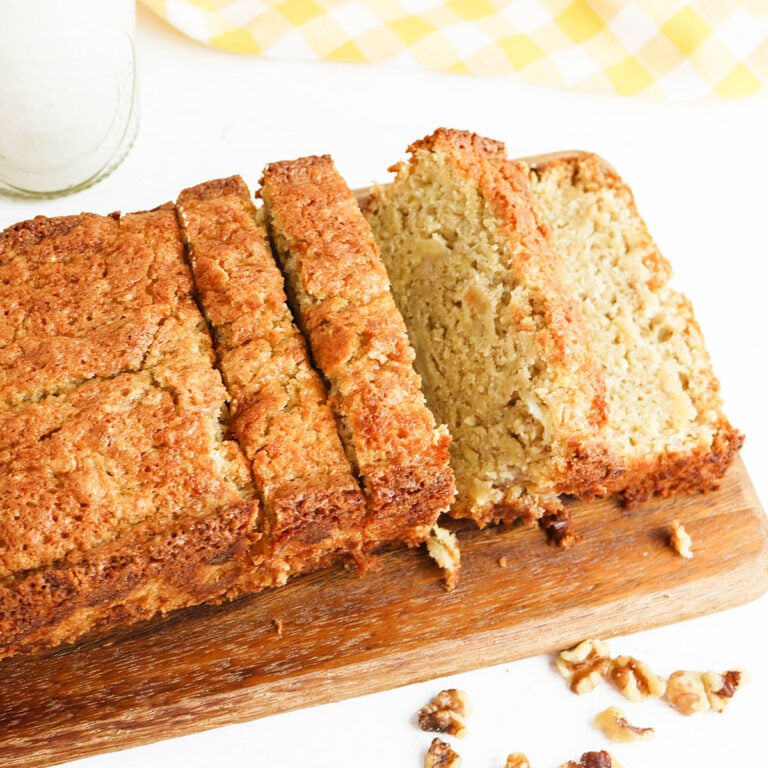 Sliced Banana Nut Bread on wooden serving board.