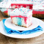 Slice of 4th of July Poke Cake on white plate.