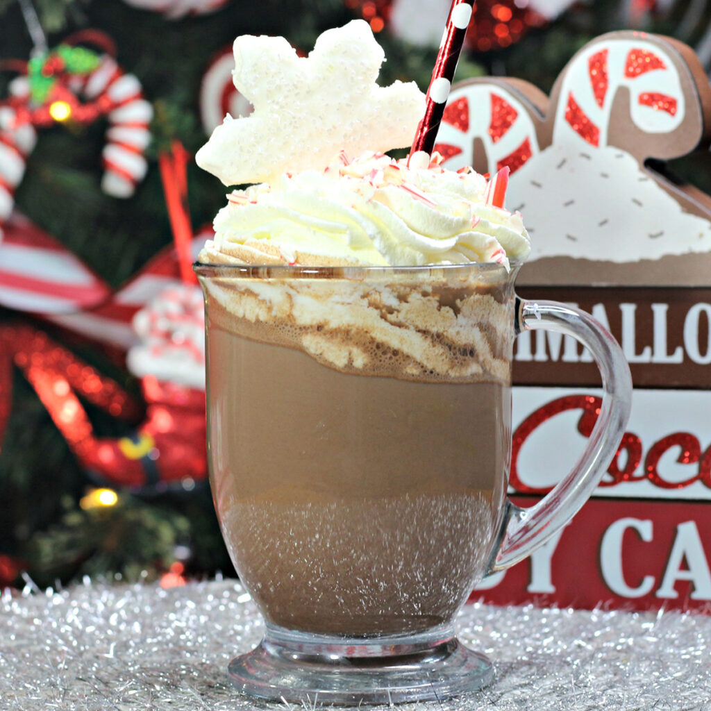 Peppermint Hot Cocoa in glass mug topped with whipped cream.