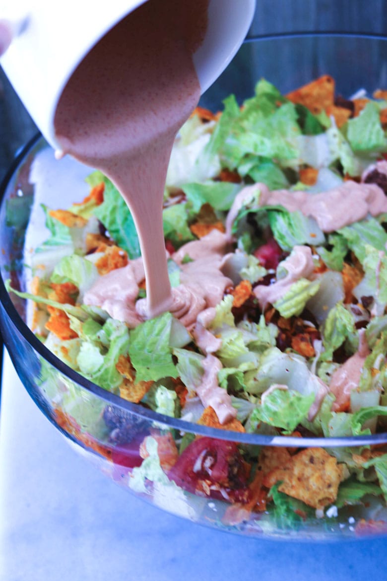 Pouring Taco Salad Dressing In Bowl