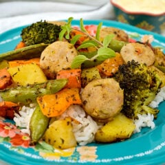 Paprika Herb Roasted Veggies and Sausage on top of rice on blue plate