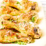 Parmesan Chicken Legs on white platter serving dish