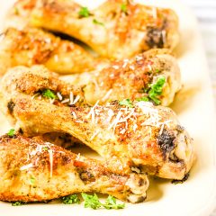 Parmesan Chicken Legs on white platter serving dish