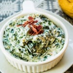 Spinach Dip in white serving bowl on white plate