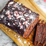 Peppermint Chocolate Pound Cake with crushed peppermint candy on top on wooden serving board
