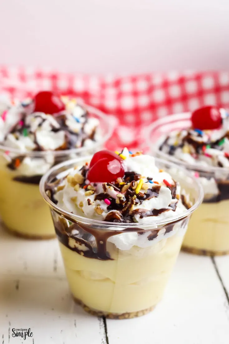 Banana Split Pudding Cup topped with chocolate syrup and sprinkles