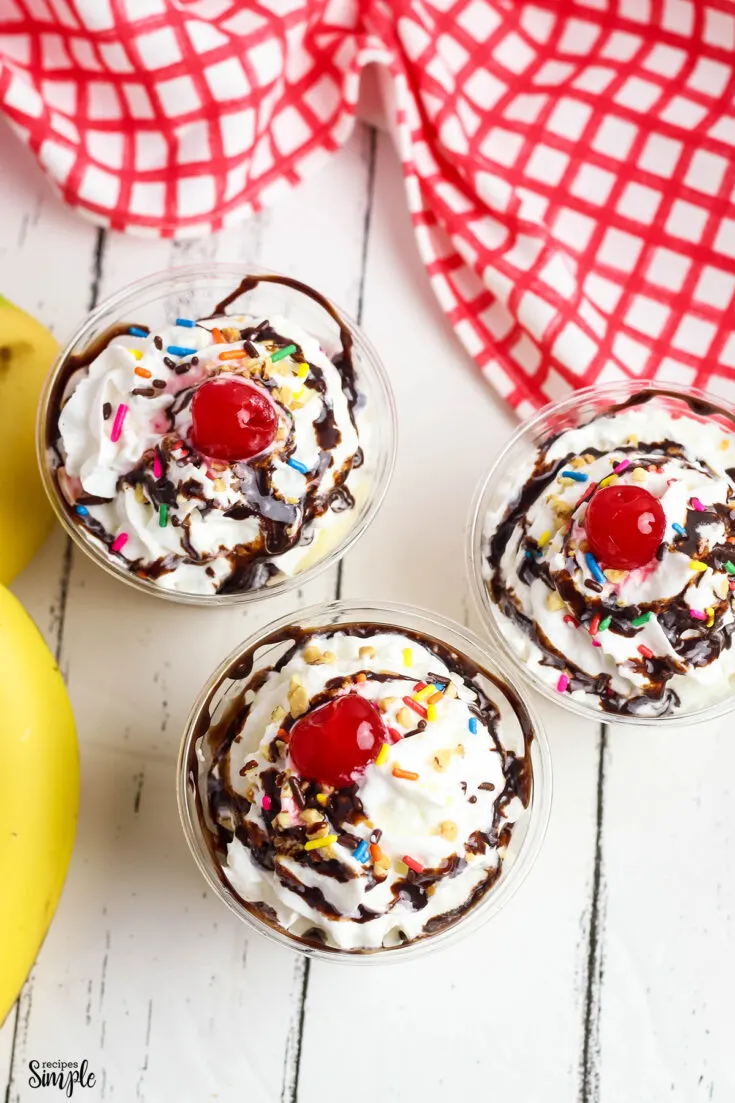 Banana split pudding dessert in clear plastic serving cups