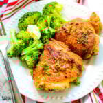 Parmesan Roasted Chicken Thighs on white plate with a side of broccoli