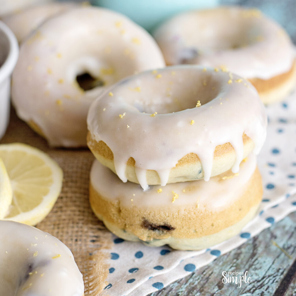 Lemon Blueberry Glazed Donuts stacked on white and blue dot napkin