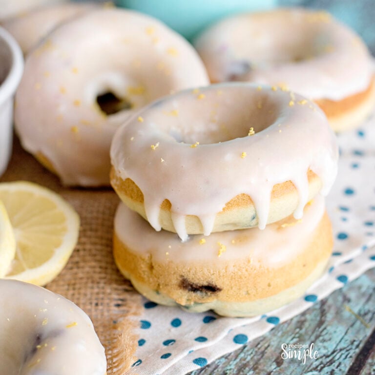 Lemon Blueberry Glazed Donuts stacked on white and blue dot napkin