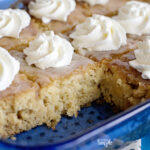 Pineapple Poke Cake in Blue Glass Dish Topped With Whipped Cream
