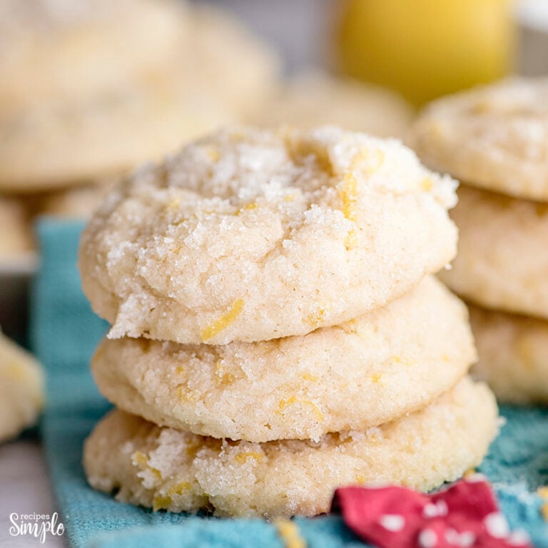 Three Lemon Sugar Cookies stacked on teal color kitchen hand towel
