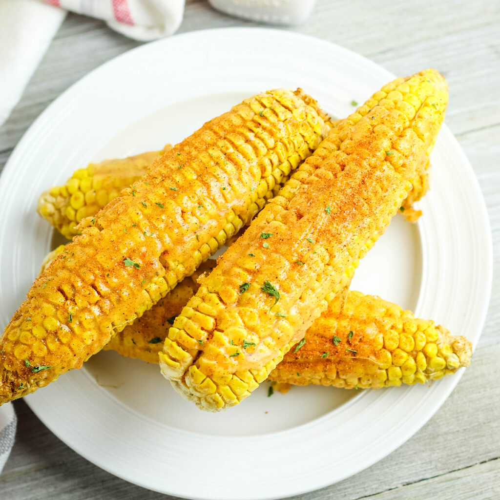 4 Cajun Corn On The Cobs on white plate