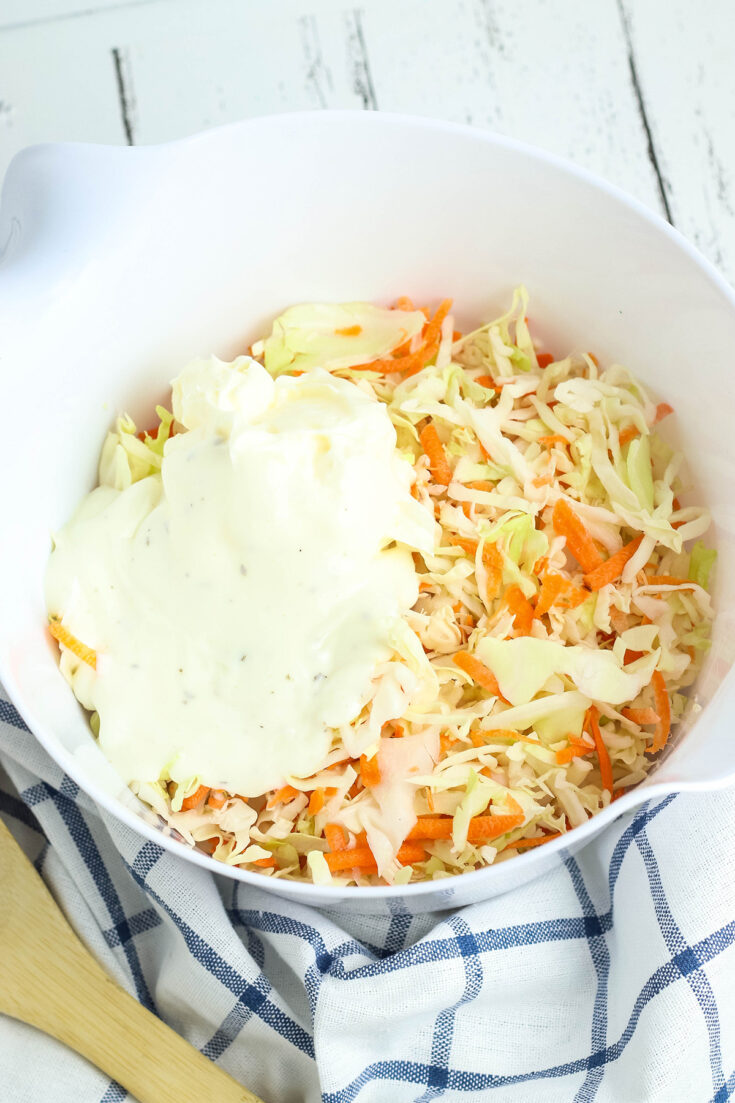 Dressing added to coleslaw in bowl