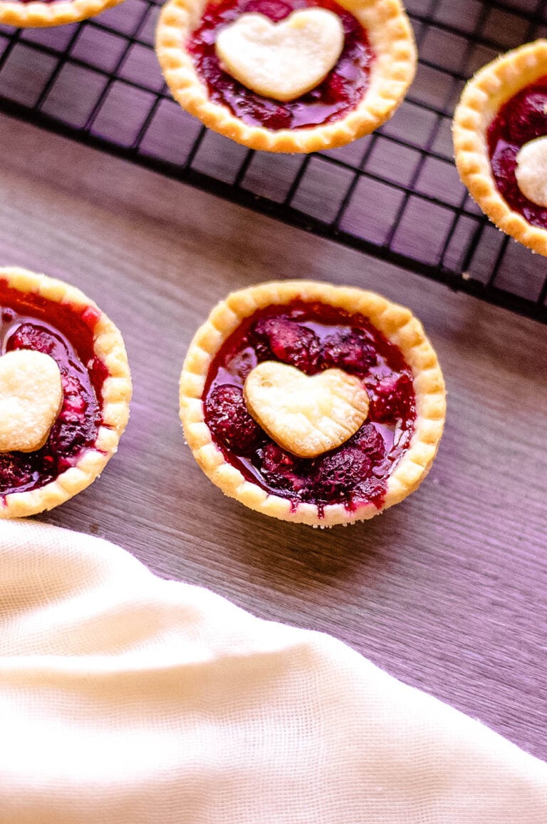 Mini Raspberry Tarts on wooden counter and cooling rack