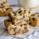 2 Rolo Chocolate Chip Cookie Bars stacked on top of each other on kitchen towel