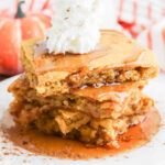 Pumpkin Pancake squares stack on top of each other topped with syrup and a dusting of cinnamon.