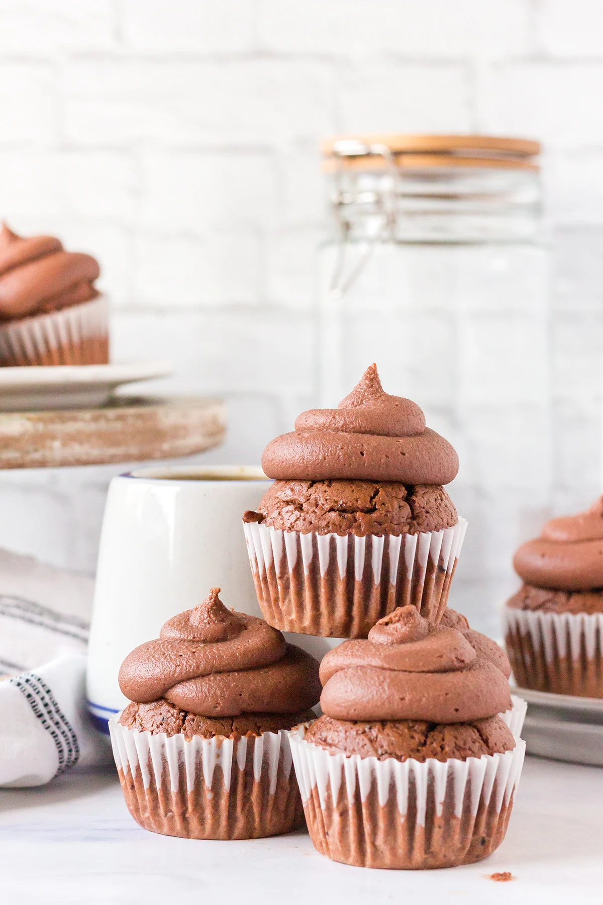Frosted Mocha Cupcakes stacked on white marble counter.