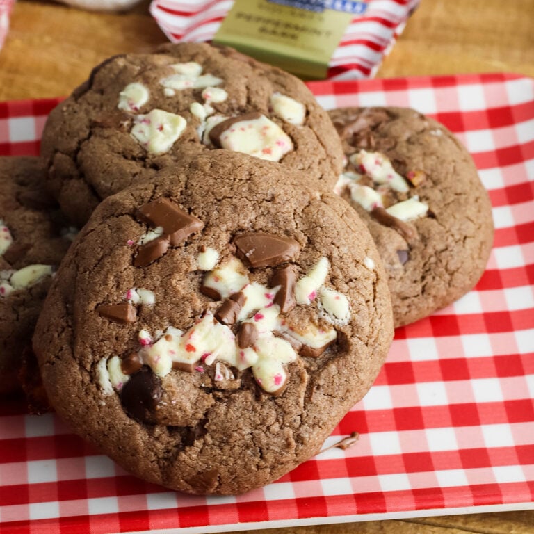Four Chocolate Peppermint Cookies stacked on red and white Gingham plate.