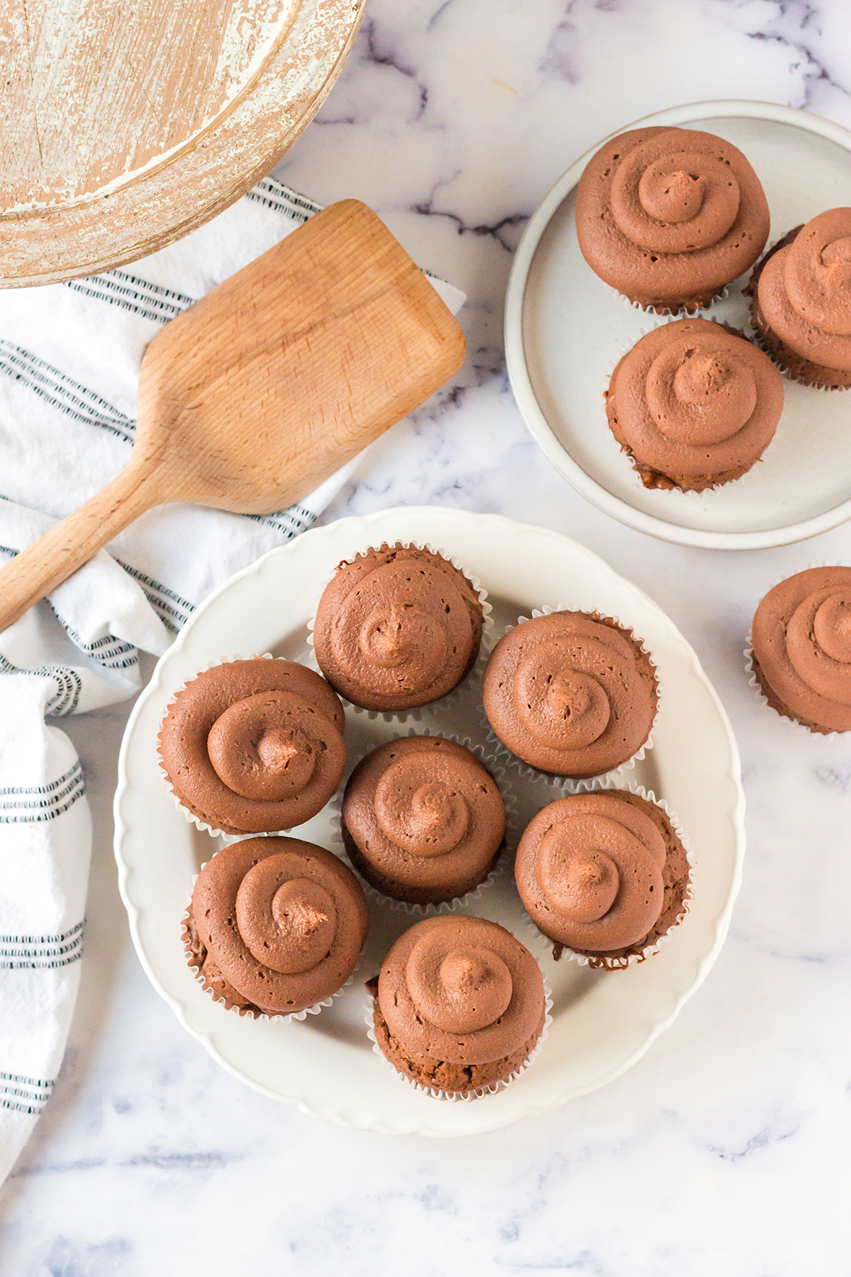 Seven Mocha Cupcakes with Chocolate Frosting on white plate.