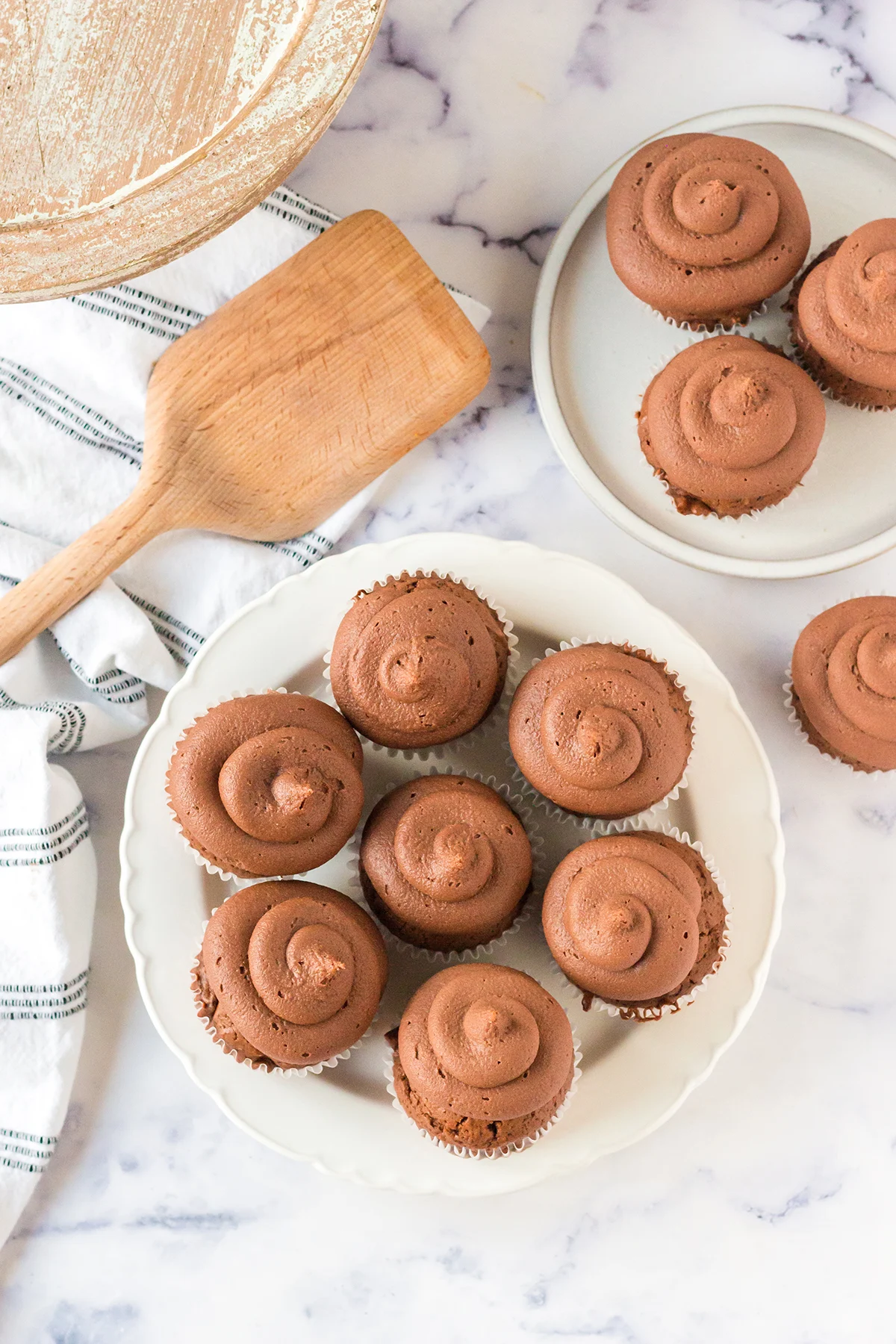 Seven Mocha Cupcakes with Chocolate Frosting on white plate.