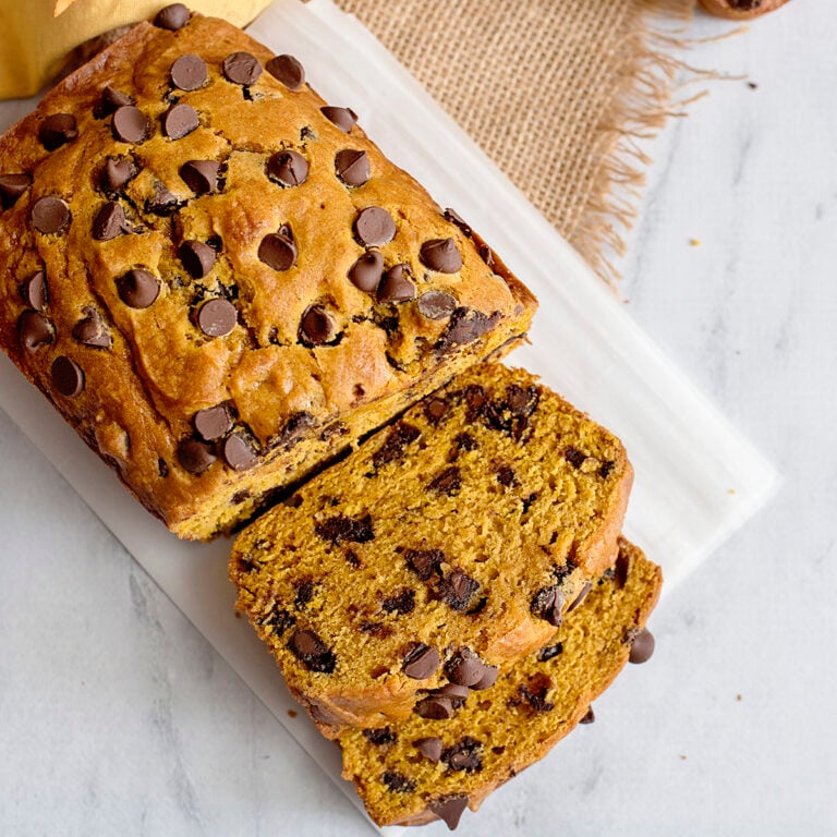 Pumpkin Chocolate Chip Loaf with two slices on white serving board.