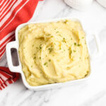 Cheesy Garlic Mashed Potatoes in white serving dish.