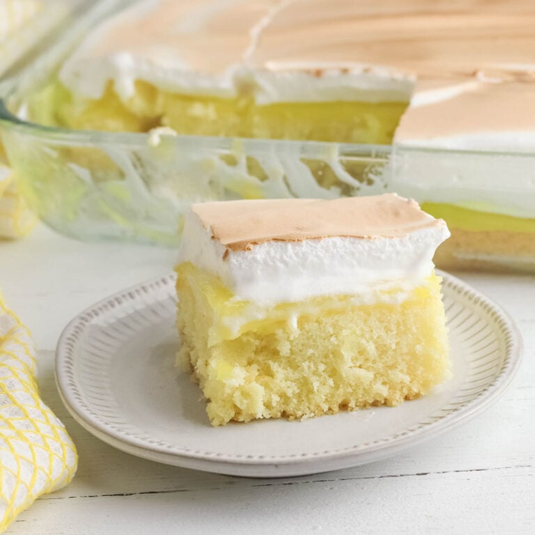 A slice of Lemon Meringue Poke Cake on white plate.