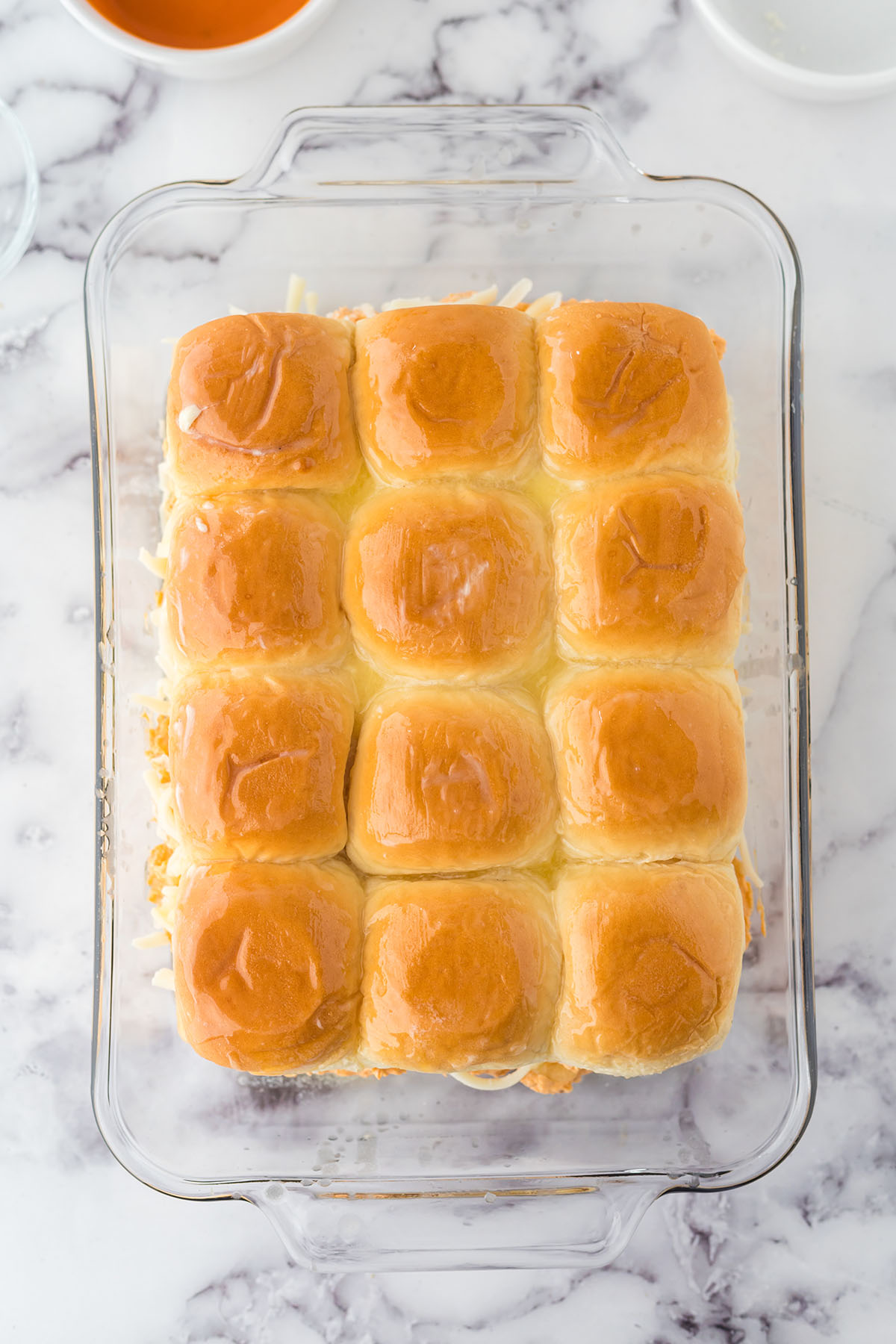Top half of rolls placed over chicken mixture in glass baking dish.