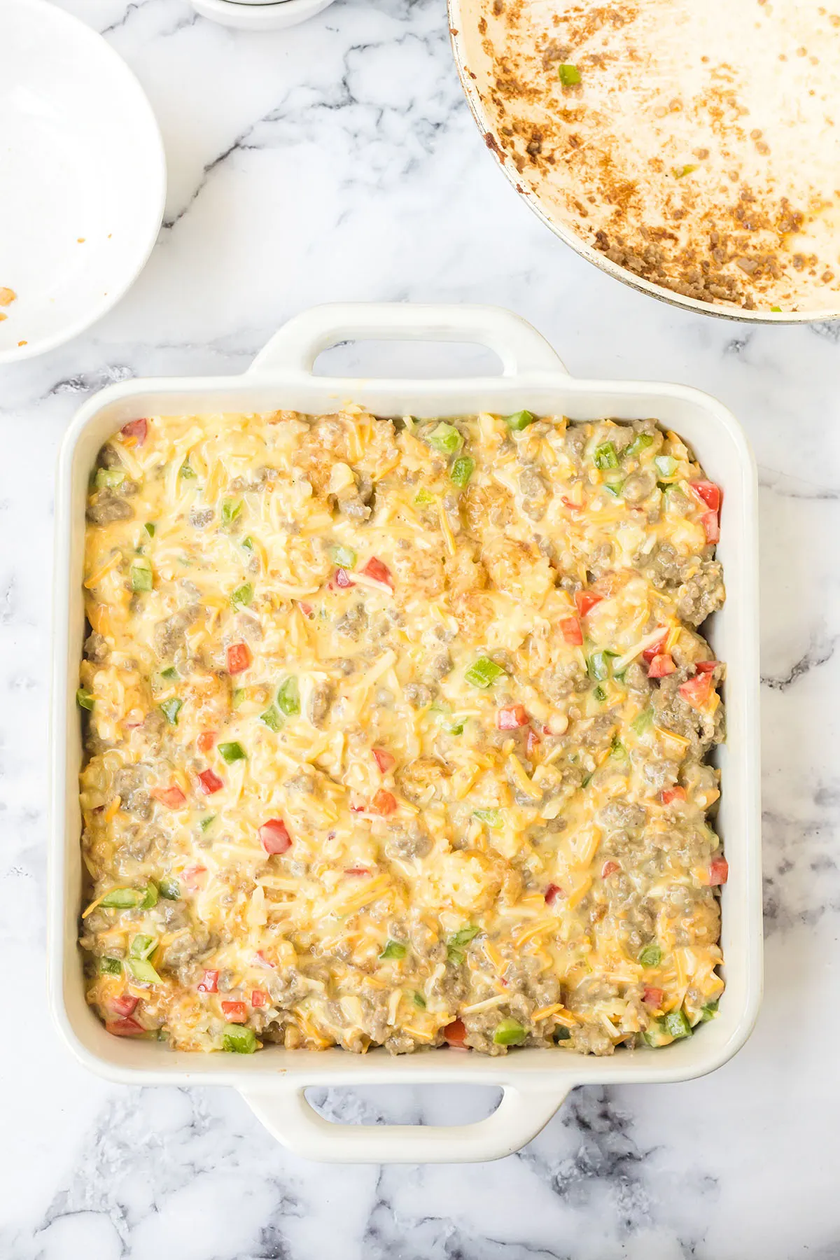 Breakfast casserole ingredients in baking dish ready to bake.