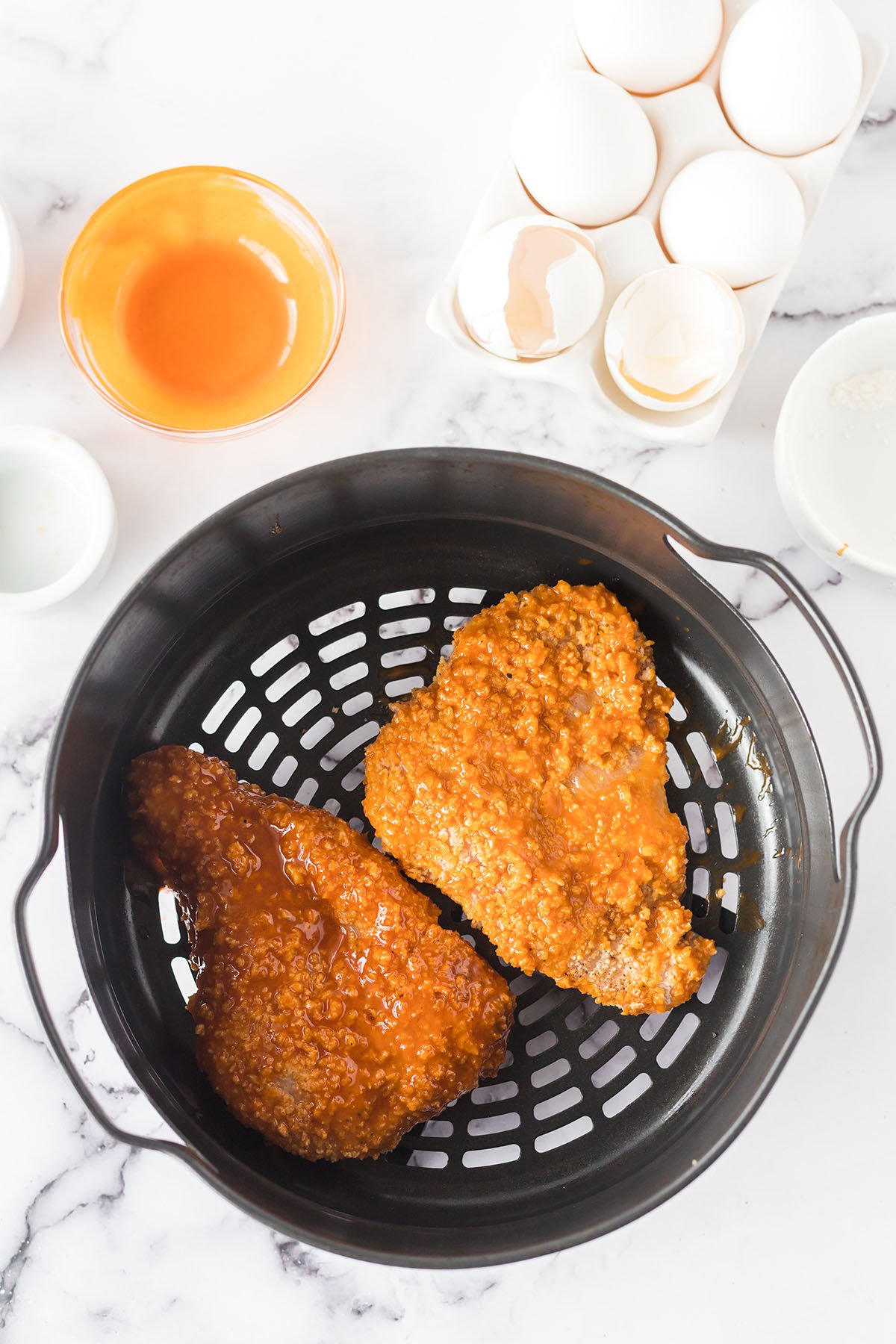 Buffalo Chicken breasts in air fryer basket.