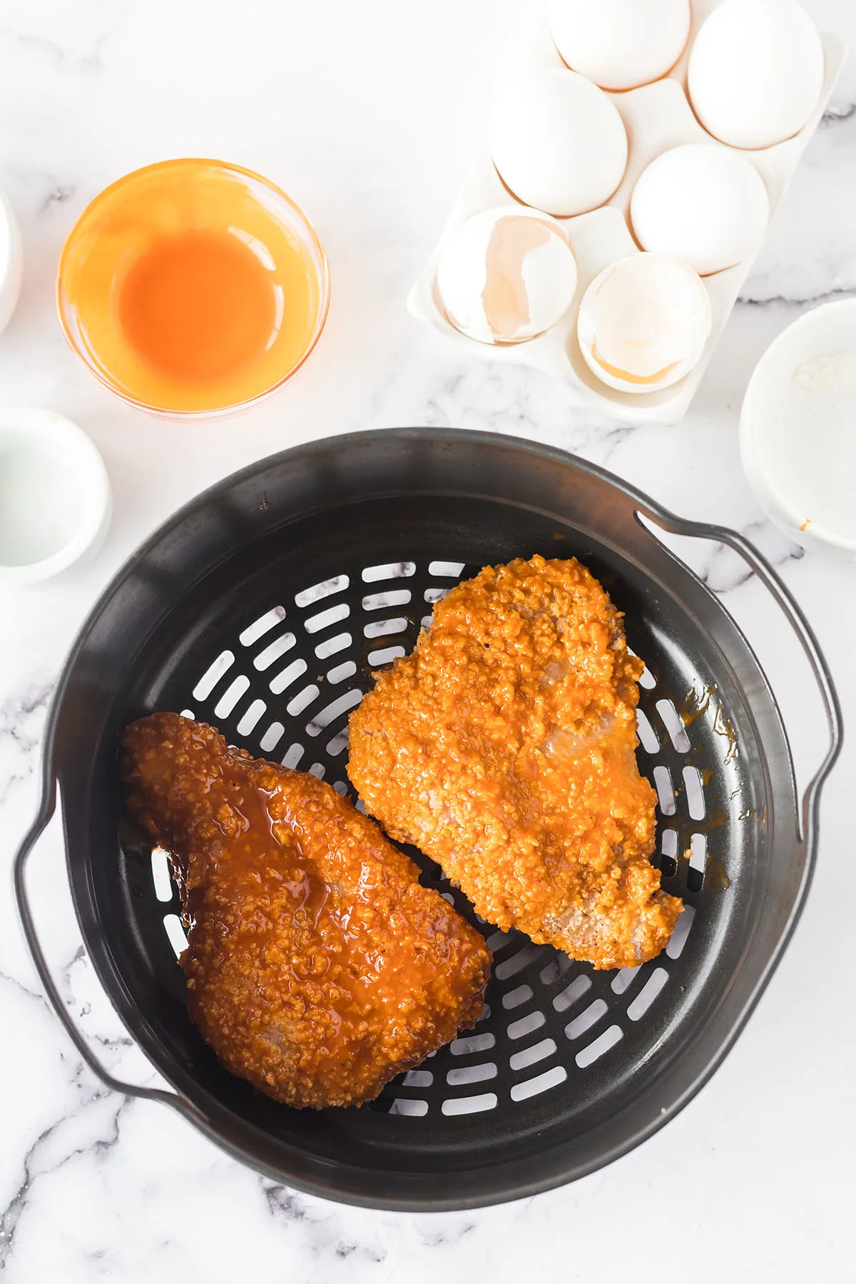 Buffalo Chicken breasts in air fryer basket.