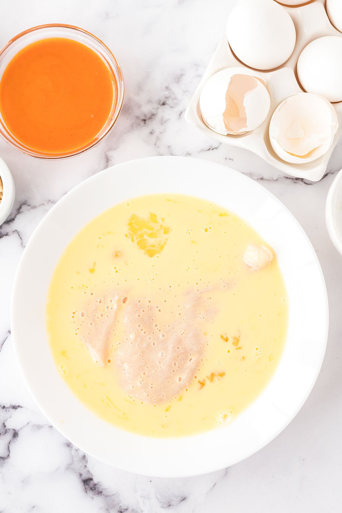 Chicken dipped in egg and milk mixture.