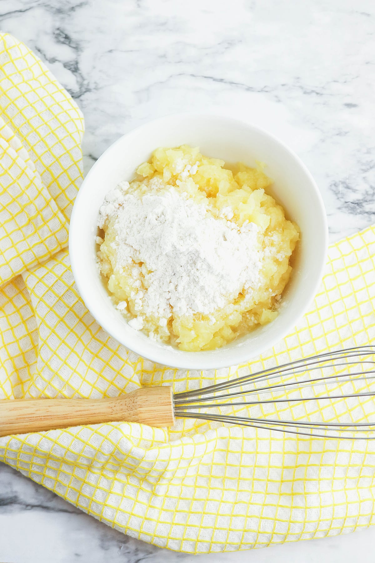 Drained pineapple in mixing bowl with flour.