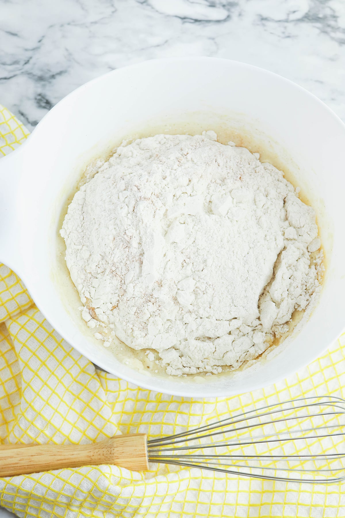 Dry ingredients added to wet ingredients in mixing bowl.