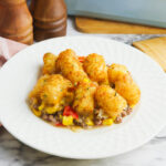 Serving of Tater Tot Casserole on white plate.