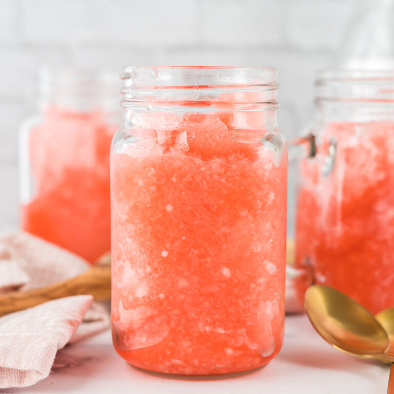 Three Fruit Punch Slushies in mason style jar with handle on counter.