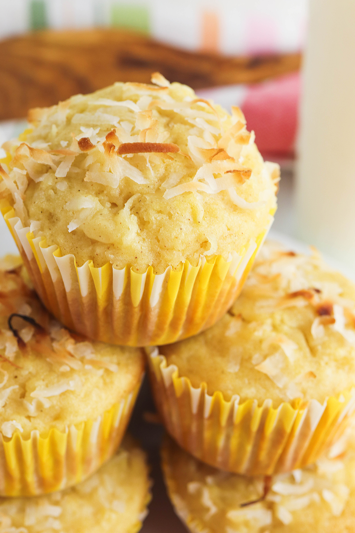 Five stacked Pineapple Coconut Muffin on white plate.