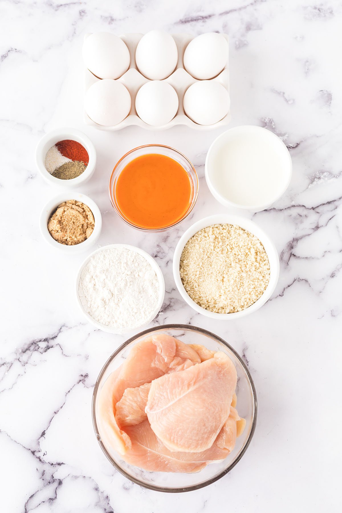 Ingredients for Buffalo chicken set out on marble counter.