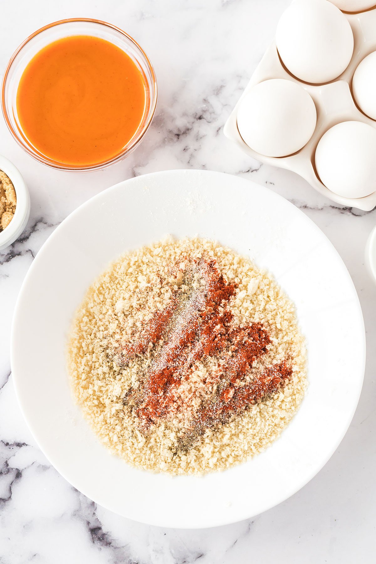 Panko bread crumbs and seasonings in white bowl.