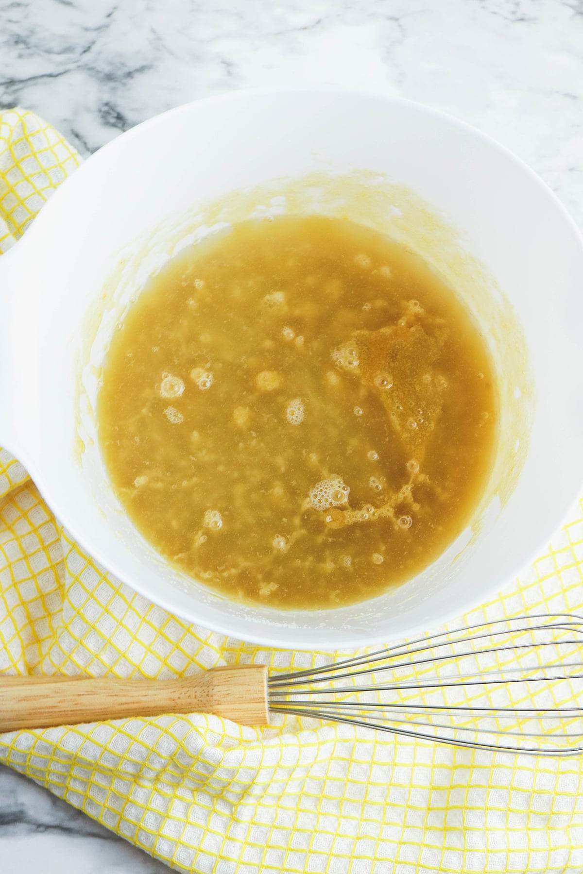 Pineapple juice added to brown sugar mixture in mixing bowl.