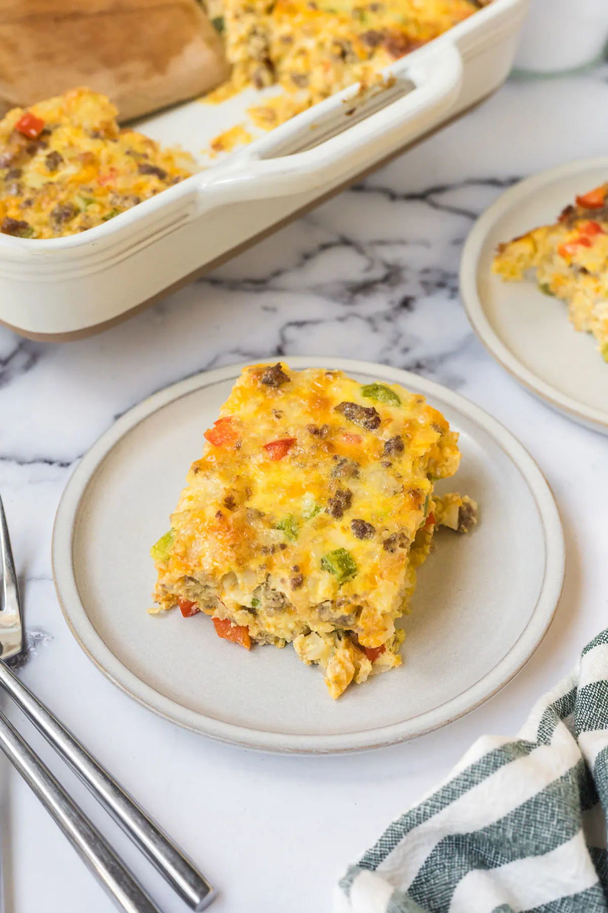 Slice of baked Tater Tot Breakfast Casserole on plate.