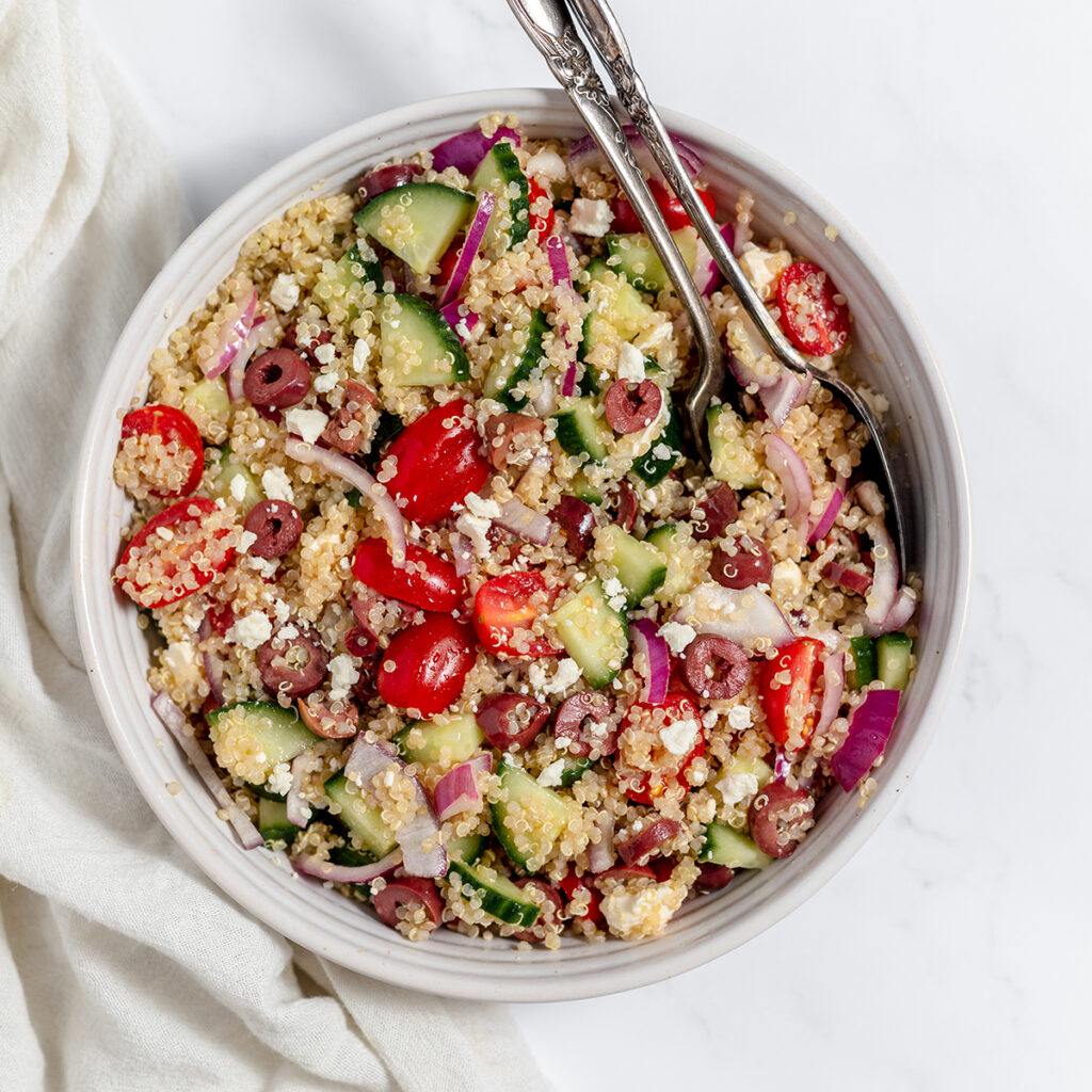 Greek Quinoa Salad in large white serving bowl.