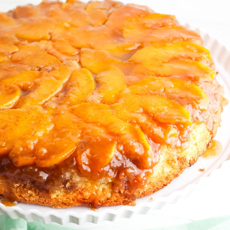 Peach Upside Down Cake on white cake stand.
